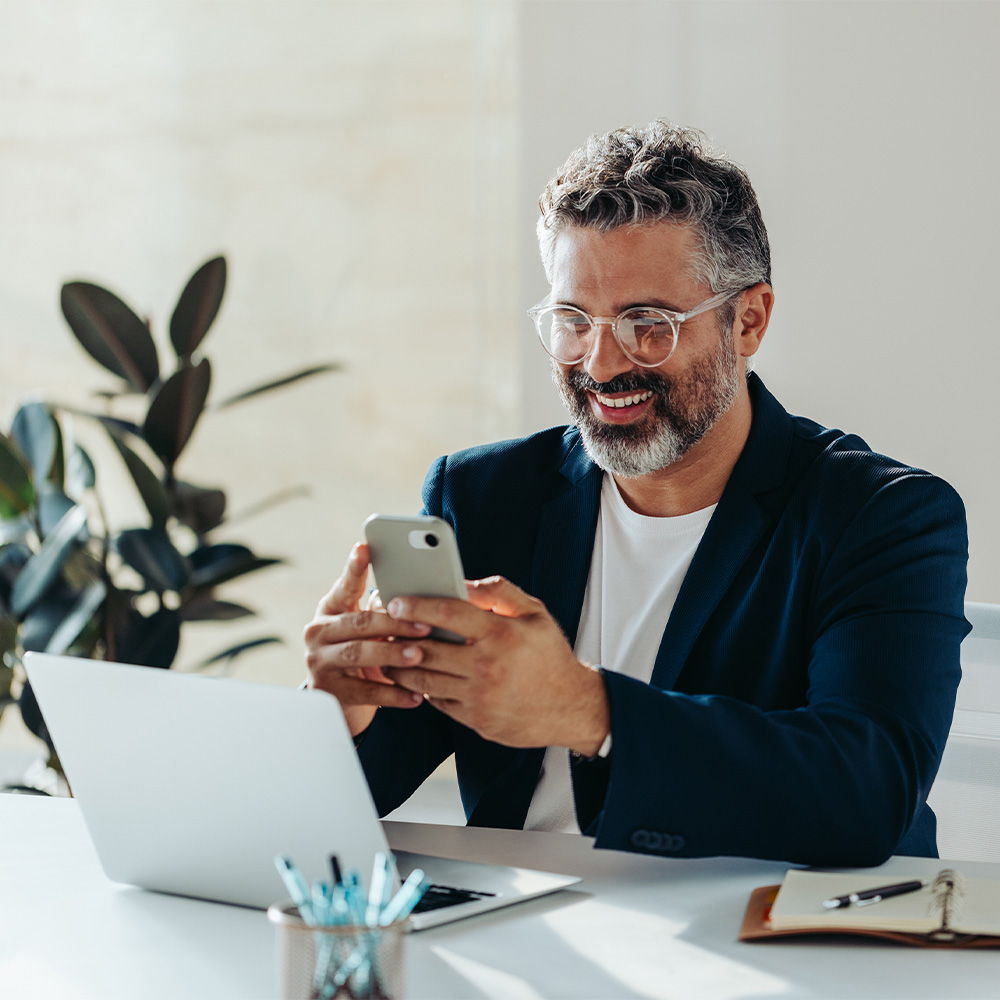 Man smiling at his phone showing a satisfied customer